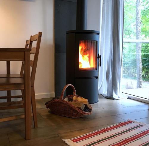 a wood stove in a living room with a basket at 3pokoje - Domek lub Pokój pod lasem na odludziu, jacuzzi, sauna, kominek, Roztocze in Susiec