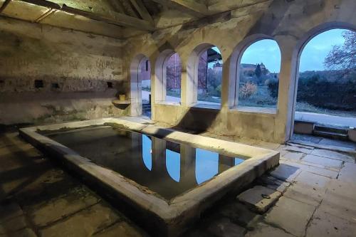 una piscina de agua en una habitación con ventanas en Agréable maison 8 personnes WIFI et clim, en Marmeaux