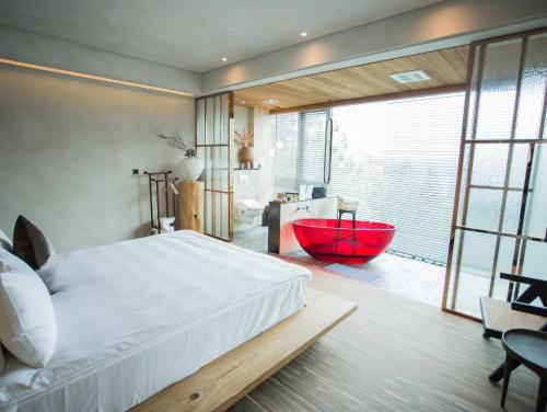 a bedroom with a large bed and a red tub at The Forest Museum in Zhuolan