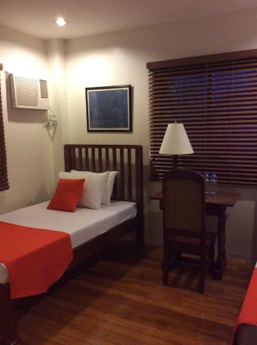 a bedroom with a bed and a desk with a chair at Casa Roces in Legazpi