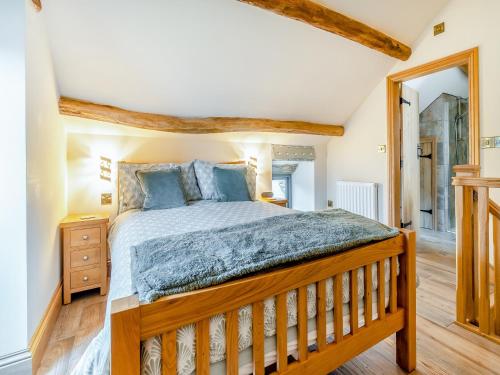 a bedroom with a wooden bed and a mirror at Little Pythorn - Uk45253 in Westerdale