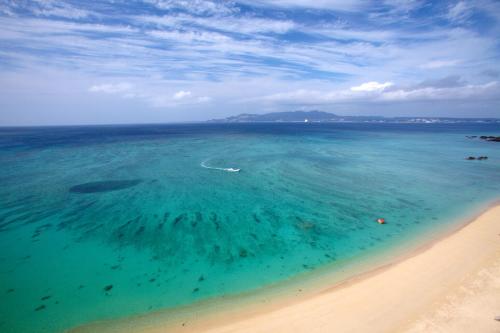an aerial view of a beach with a boat in the water at Best Western Okinawa Kouki Beach in Nago