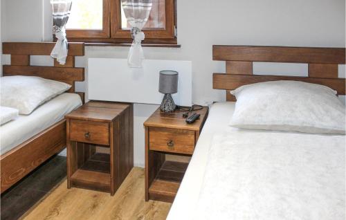 een slaapkamer met 2 bedden en een lamp op een nachtkastje bij Pet Friendly Home In Korenica With Kitchen in Korenica