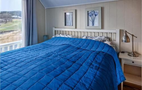 a blue bed in a bedroom with a window at Amazing Apartment In Hemnskjela With Kitchen 