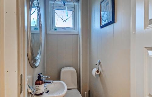 a bathroom with a sink and a toilet and a window at Amazing Apartment In Hemnskjela With Kitchen 