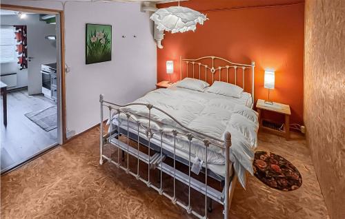 1 dormitorio con 1 cama con pared de color naranja en 2 Bedroom Stunning Home In Grsmark, en Gräsmark