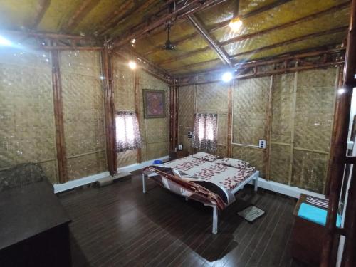 - une chambre avec un lit dans une pièce avec du papier peint dans l'établissement Vasant Bamboo Cottage, à Maheshwar