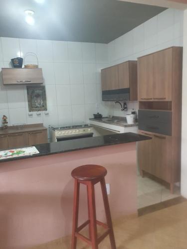 a kitchen with a bar with a stool in it at Casa temporada da Nenê in Ipitangas