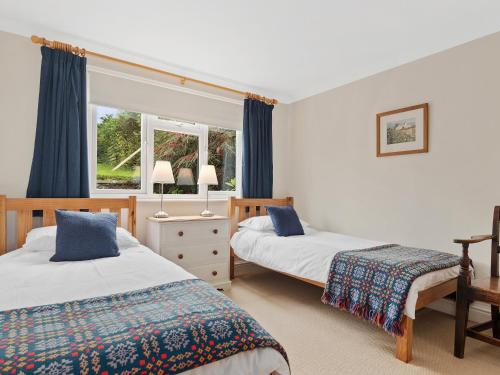 a bedroom with two beds and a window at Ty Gwartheg in Trevine