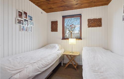 two beds in a room with a table and a window at Amazing Home In Ebeltoft With Wifi in Ebeltoft