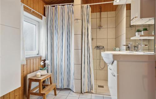 埃伯爾措夫特的住宿－3 Bedroom Amazing Home In Ebeltoft，浴室配有淋浴帘和盥洗盆。