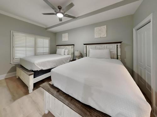a bedroom with two beds and a ceiling fan at Adagio 105B in Santa Rosa Beach