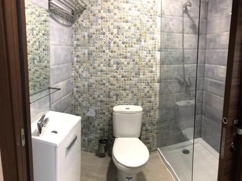 y baño con aseo, lavabo y ducha. en Casa Navajas, en Jérica