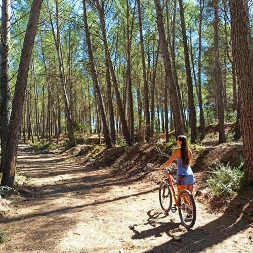 a woman riding a bike on a dirt road at Casa Navajas in Jérica