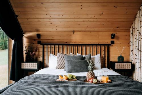 a bedroom with a bed with a tray of fruit on it at ArtHouse Podhale in Klikuszowa