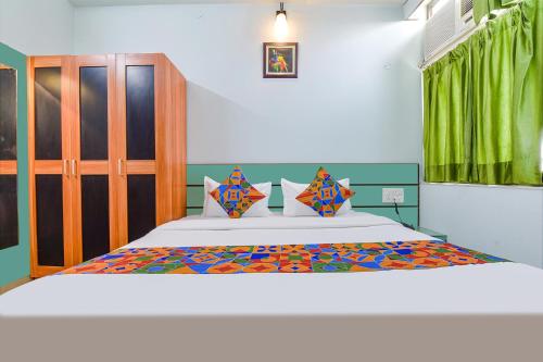een slaapkamer met een groot bed met een kleurrijke sprei bij FabHotel Aayojan in Jaipur