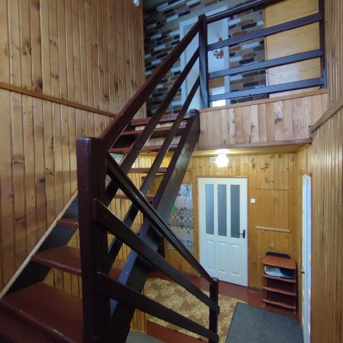 a spiral staircase in a cabin with a door at Садиба "У стрийка" Сопіт in Sopot