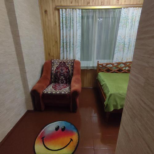 a living room with a chair and a bed at Садиба "У стрийка" Сопіт in Sopot