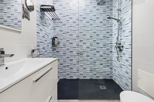 une salle de bain avec une douche avec un lavabo et des toilettes dans l'établissement Home2Book Modern Apt Puerto del Carmen, Terrace, à Puerto del Carmen