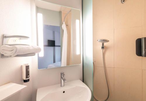 La salle de bains est pourvue d'un lavabo et d'un miroir. dans l'établissement B&B HOTEL Limoges 1, à Limoges
