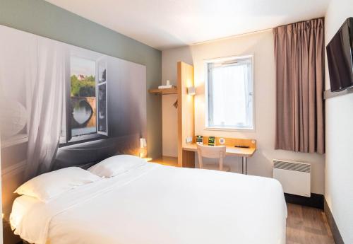 سرير أو أسرّة في غرفة في B&B HOTEL Limoges 1