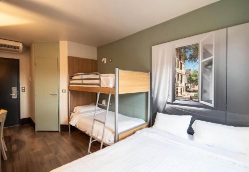 1 Schlafzimmer mit 2 Etagenbetten und einem Fenster in der Unterkunft B&B HOTEL Limoges 1 in Limoges