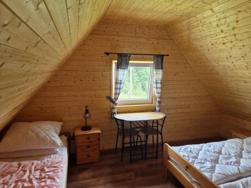 sypialnia z łóżkiem i stołem na poddaszu w obiekcie Chaty u lesa w mieście Velké Hamry