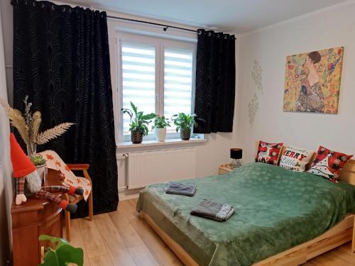 sypialnia z zielonym łóżkiem i oknem w obiekcie Apartament Gustav w mieście Zawiercie