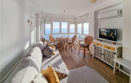 a living room with a couch and a television at Beach Front Apartment In Algarrobo-costa With Outdoor Swimming Pool in Algarrobo-Costa