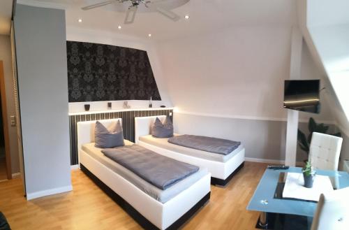 NossenにあるPension&Wellness-Oase-Nossenのベッド2台とテーブルのある寝室