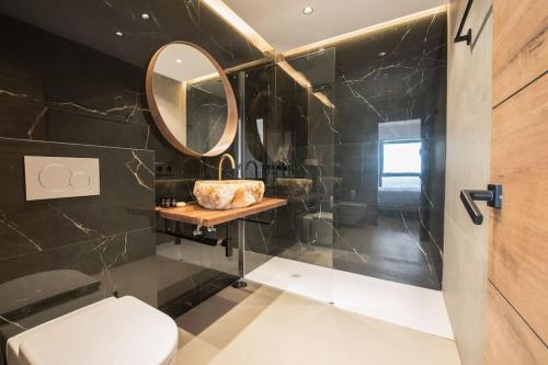 ein Badezimmer mit Toilette und Spiegel in der Unterkunft Luxury piso Nijota NEW in Santa Cruz de Tenerife