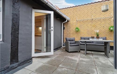 a patio with a table and a chair next to a building at Pet Friendly Home In Rønne With Kitchen in Rønne