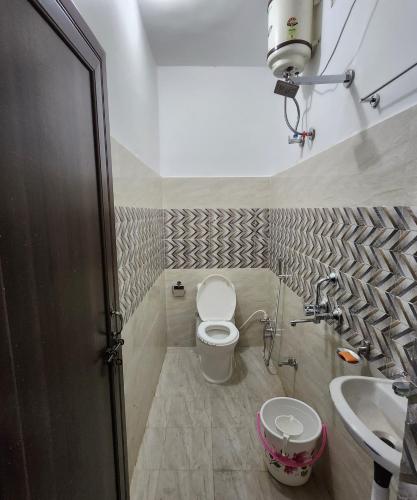 a bathroom with a toilet and a sink at The kashi palace inn ,Varanasi ! fully-Air-Conditioned hotel at prime location with Parking availability, near Kashi Vishwanath Temple, and Ganga ghat in Varanasi