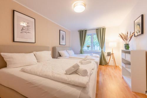 - une chambre avec un grand lit blanc et une fenêtre dans l'établissement Stay Awesome - Weinberg Residence Comfort in zentraler Lage, à Cassel