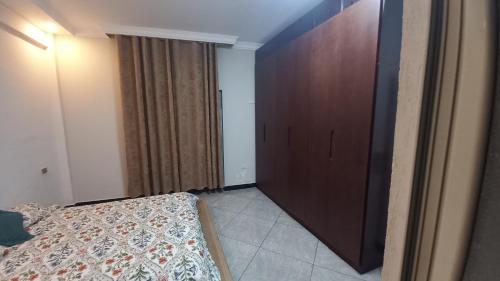 una camera con letto e armadio in legno di G&19 Apartment ad Addis Abeba