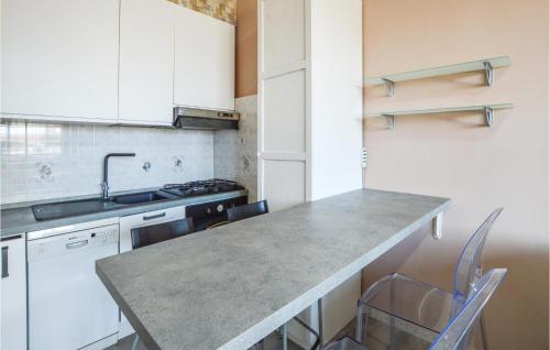a kitchen with a counter with chairs and a sink at Stunning Apartment In Varazze With Wifi in Varazze