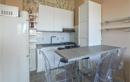 a kitchen with white cabinets and a counter with stools at Stunning Apartment In Varazze With Wifi in Varazze