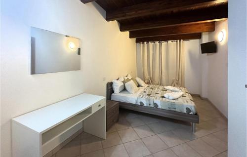 Stunning Apartment In Lecce Nei Marsi With Wi-fi في Gioia dei Marsi: غرفة نوم صغيرة بها سرير ومقعد