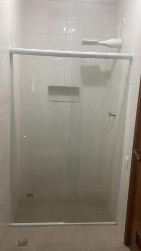 a glass shower door in a bathroom at Pousada As Ondas in Guarujá