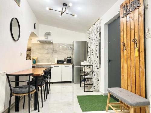 a kitchen and dining room with a table and chairs at Apartament - Voineasa -Aproape de Domeniul Schiabil in Voineasa