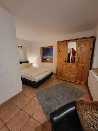 a bedroom with a bed and a cabinet and a couch at Hotel Post - Garni in Bichlbach