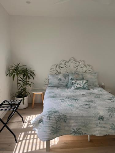Bett in einem Zimmer mit einer weißen Wand in der Unterkunft Plateau Of The Seas in Collaroy
