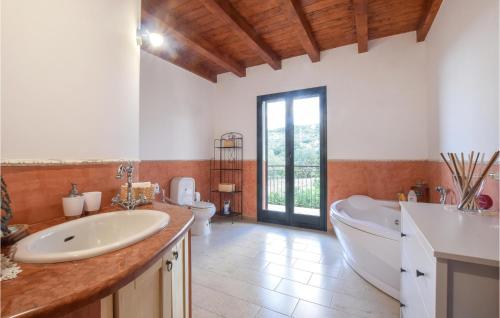 a bathroom with two sinks and a tub and a toilet at 4 Bedroom Awesome Home In Caronia in Caronia