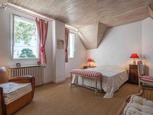 a bedroom with a bed and a couch and a window at Villa La Trinité-sur-Mer, 5 pièces, 8 personnes - FR-1-477-6 in La Trinité-sur-Mer