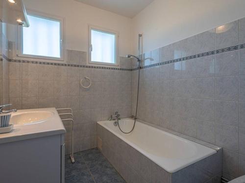 a bathroom with a bath tub and a sink at Villa La Trinité-sur-Mer, 5 pièces, 8 personnes - FR-1-477-6 in La Trinité-sur-Mer