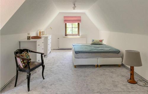 a bedroom with a bed and a chair in a attic at 2 Bedroom Beautiful Home In Burg Stargard in Burg Stargard
