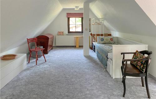 a attic bedroom with a bed and a chair at 2 Bedroom Beautiful Home In Burg Stargard in Burg Stargard