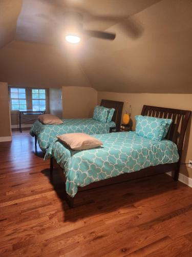 Duas camas num quarto com pisos em madeira em Midtown charm em Memphis