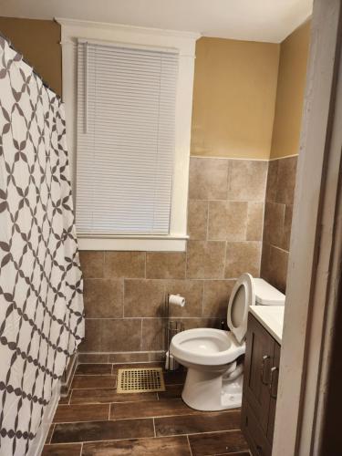 uma casa de banho com um WC e uma cortina de chuveiro em Midtown charm em Memphis