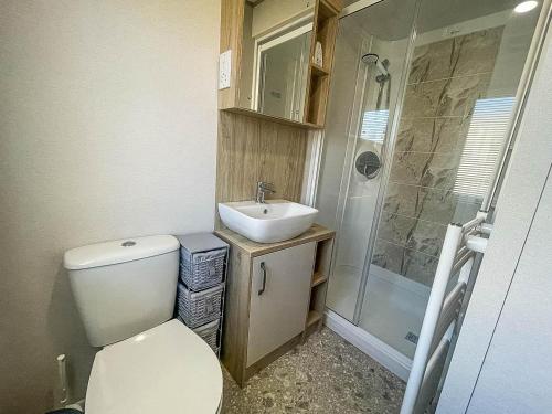 ein Bad mit einem WC, einem Waschbecken und einer Dusche in der Unterkunft Lovely Caravan With Decking At Carlton Meres Holiday Park In Suffolk Ref 60023ch in Saxmundham